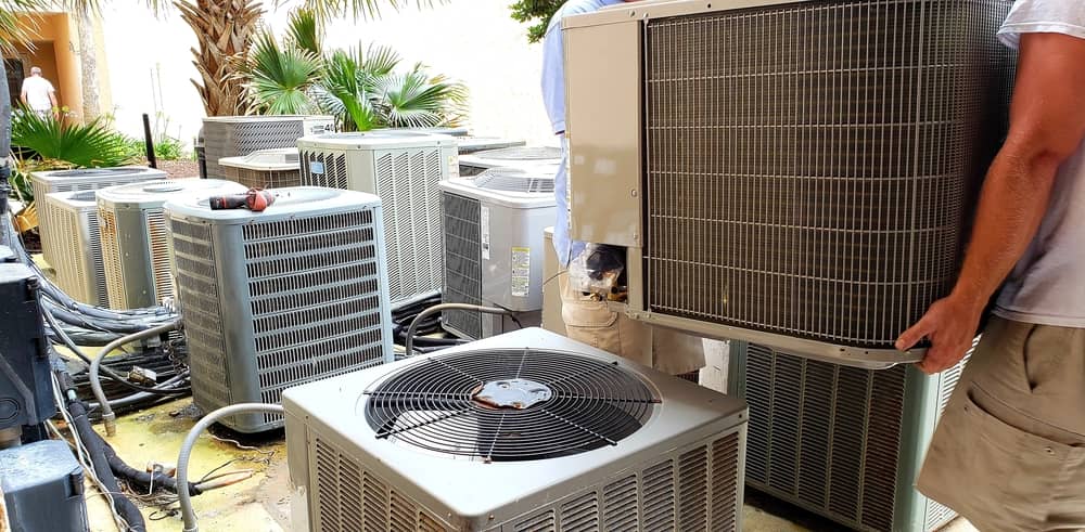 technician removing old rusted HVAC system